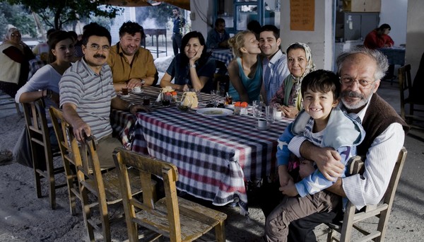 Eine große Familie sitzt um einen Essenstisch.