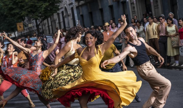 Eine Frau in einem gelben Kleid tanzt zusammen mit einer Gruppe.