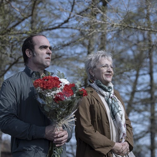 Ein Mann mit Blumen in der Hand und eine Frau.