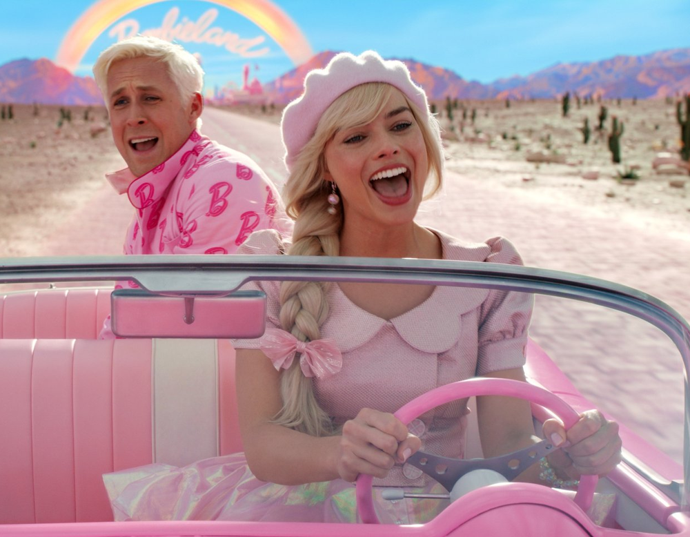 Barbie und Ken fahren in einem pinken Auto.