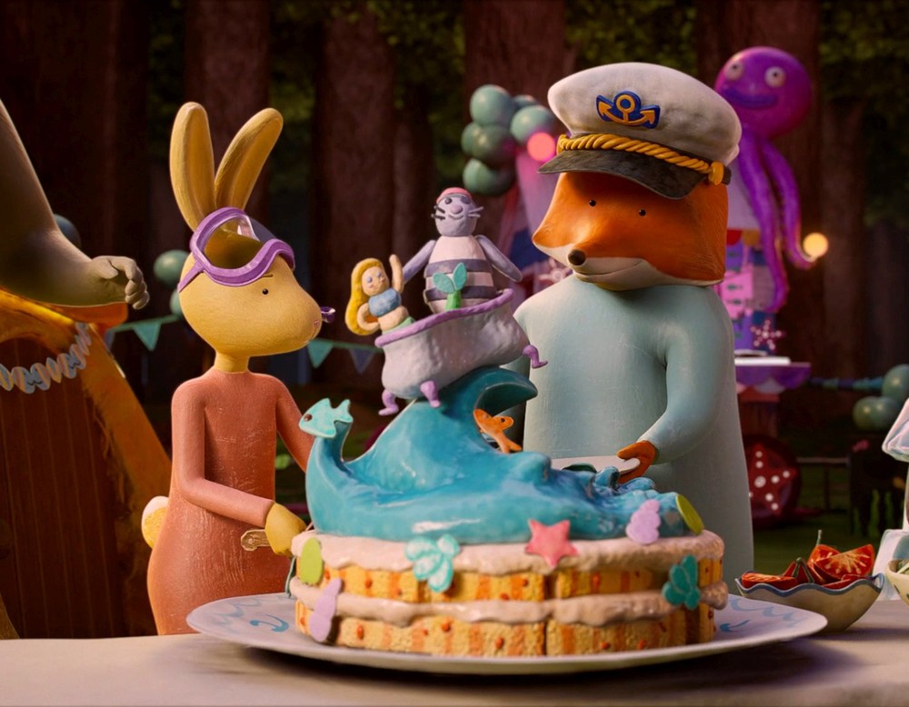 Ein Hase und ein Fuchs stehen vor einer kunstvollen Torte.