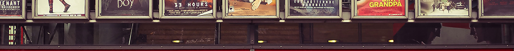 Der Eingang zu einem Kino mit Plakaten aktueller Filme darüber.