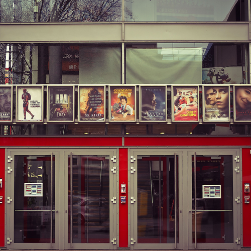 Ein altmodisches Kino von außen mit Postern aktueller Filme.