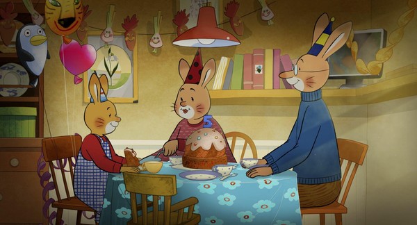 Eine gezeichnete Hasenfamilie sitzt um einen Tisch vor einem großen Geburtstagskuchen.