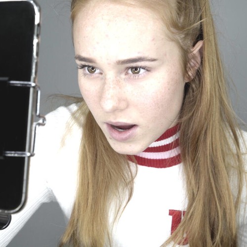 Eine Teenagerin fotografiert sich selbst mit einem Smartphone.